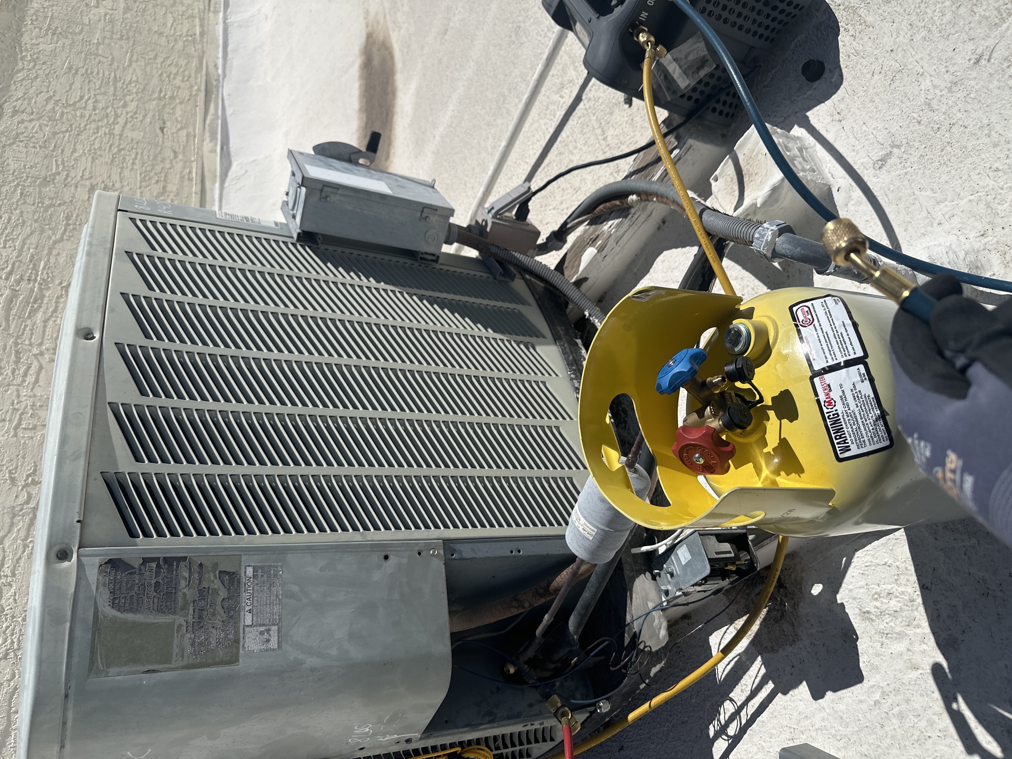 Professional refrigerant recovery equipment in use during HVAC service.