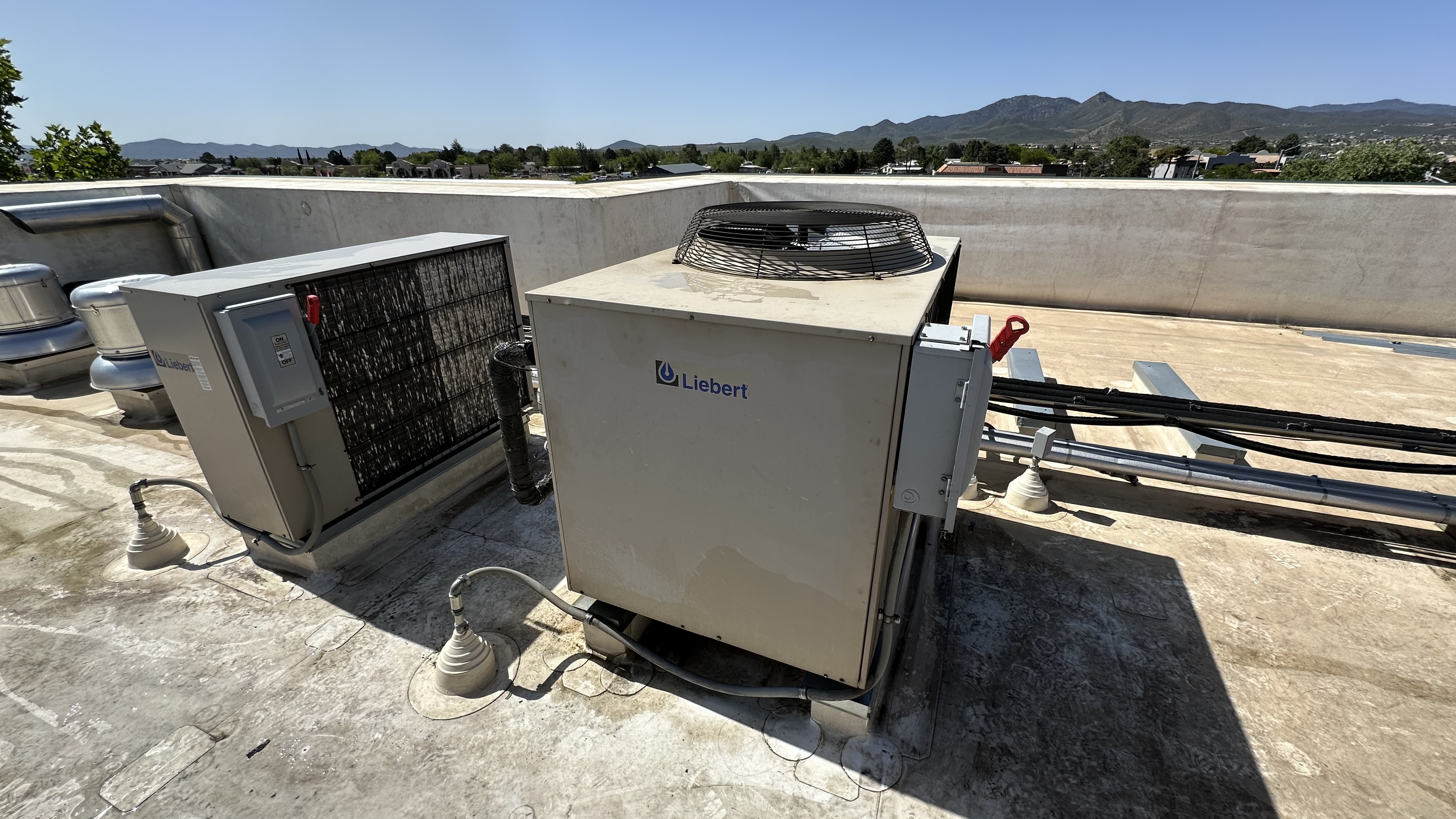 Commercial rooftop HVAC units being serviced.